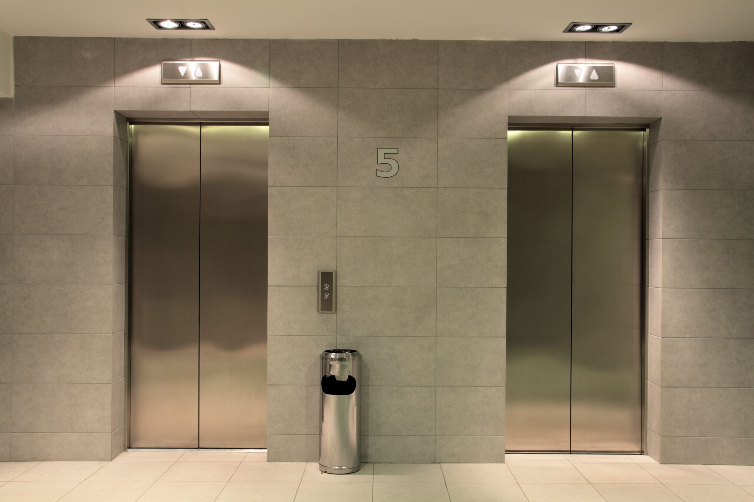 Two open elevators in a building, inviting passengers to enter or exit