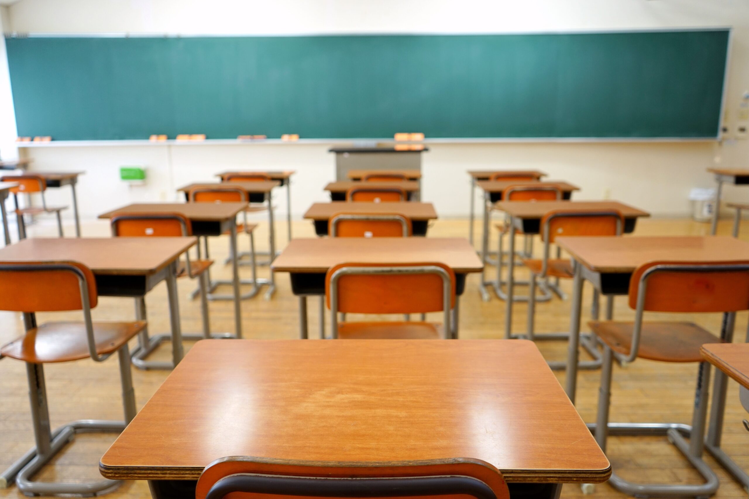 Empty desks arranged in a classroom, highlighting a quiet and unused learning environment