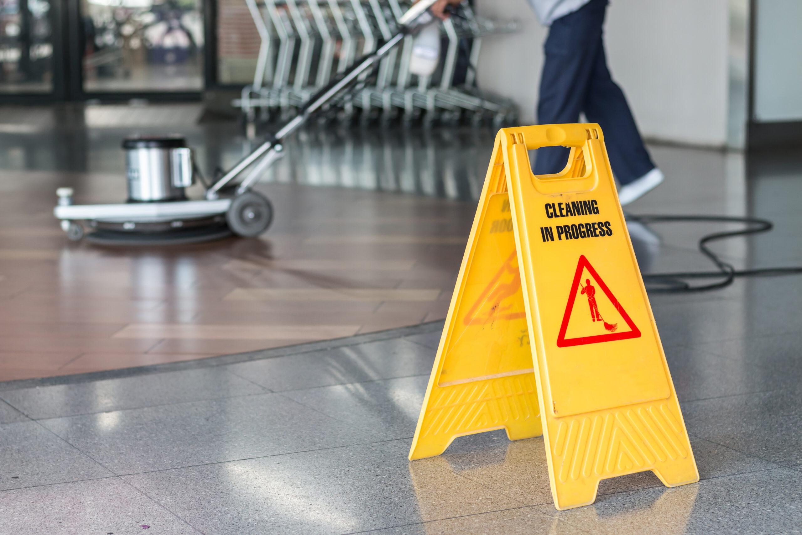 A vacuum cleaner is actively cleaning a carpet in a modern office setting